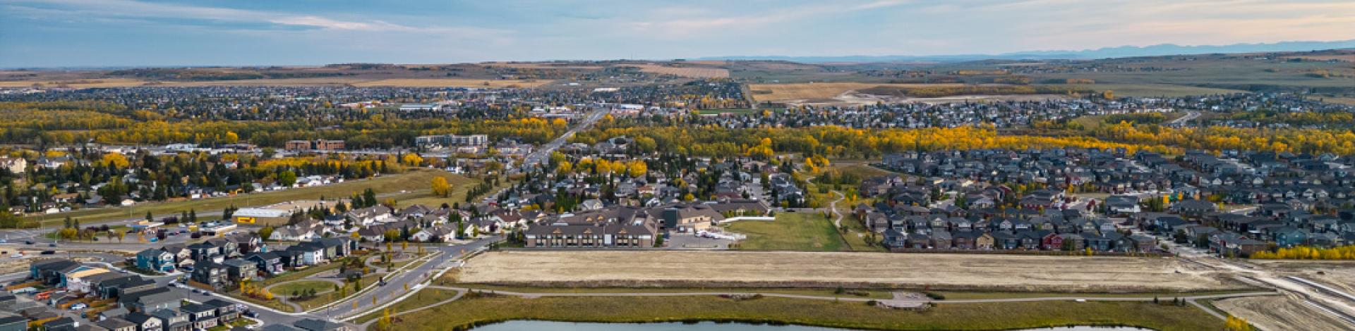 aerial view of community and homes in Okotoks around a storm pond