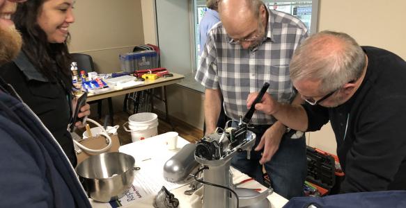 volunteer fixers repairing a mixer