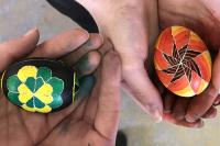 Hands holding intricately decorated eggs for Easter.