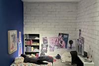 A miniature replica of a teenager's bedroom, with bed, desk, and posters on the wall.