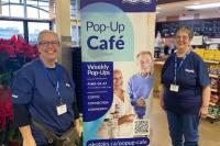 Pop up cafe banner with smiling volunteers