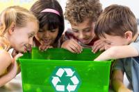 four children looking in a recycling bin