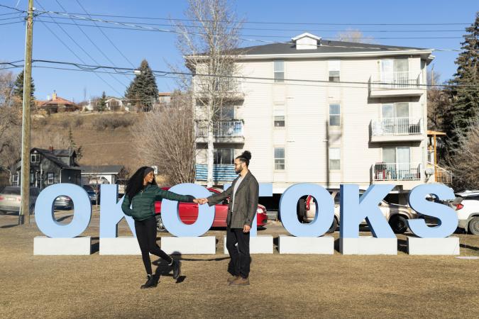 couple in fall by Okotoks letters